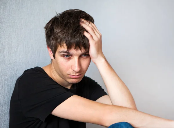 Smutny Młody Człowiek Przy Ścianie Pokoju — Zdjęcie stockowe