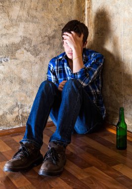 Eski duvar tarafından bir bira ile üzgün genç adam