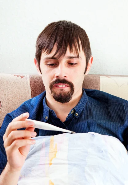 Mann Mit Medizinischem Thermometer Auf Dem Sofa Hause — Stockfoto