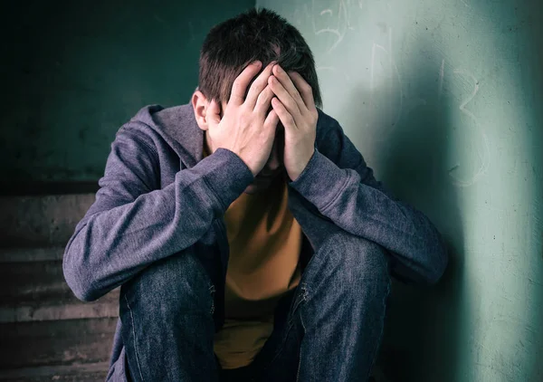 Trauriger Junger Mann Auf Dem Fußboden Neben Der Alten Mauer — Stockfoto