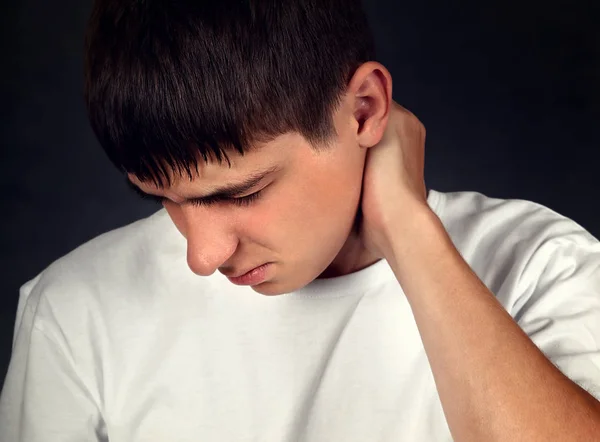 Young Man Voelt Nekpijn Tegen Donkere Achtergrond — Stockfoto