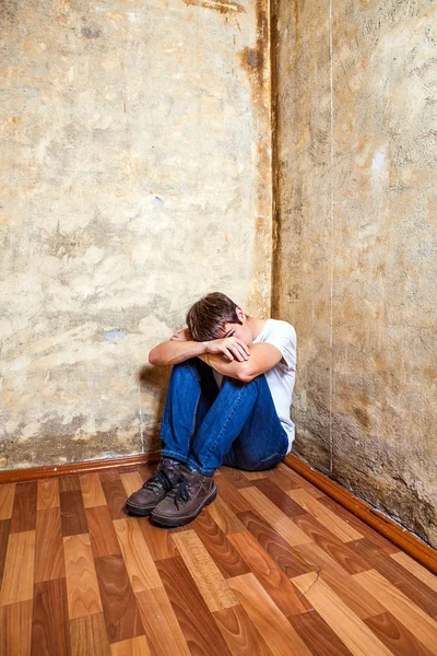 Νεαρός Άνδρας Στην Γωνία Στο Πάτωμα Από Παλιό Τείχος — Φωτογραφία Αρχείου