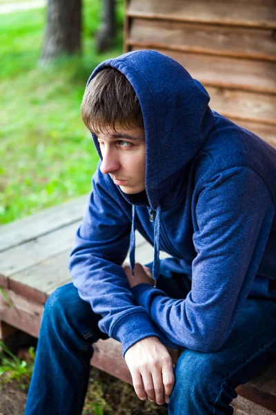 悲伤的年轻人在屋外的房子附近的帽衫 — 图库照片