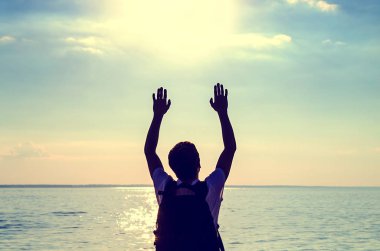 Eller yukarı deniz arka plan ile bir adam silueti tonda fotoğraf