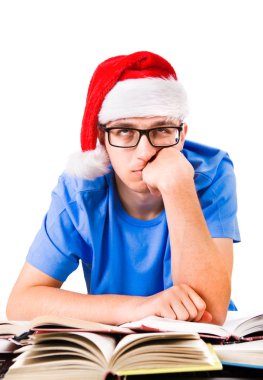 Noel Baba'nın şapkalı beyaz arka plan üzerinde izole okul masasında yorgun ve bıkkın öğrenci