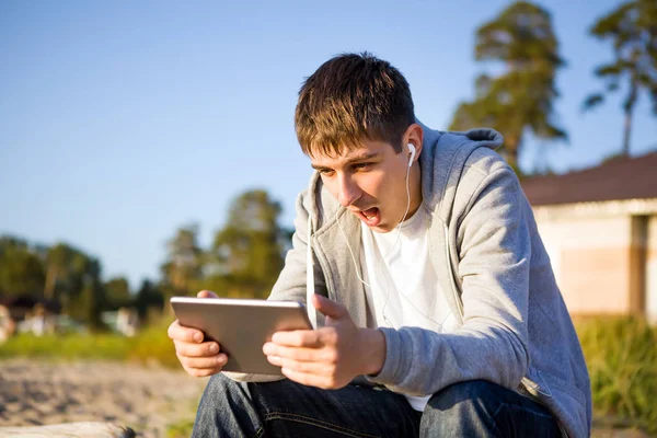 Meglepett Fiatal Ember Egy Tabletta Számítógép Fülhallgató Szabadtéri — Stock Fotó
