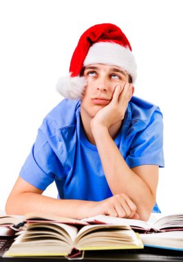 Noel Baba'nın şapkalı beyaz arka plan üzerinde izole okul masasında yorgun ve bıkkın öğrenci