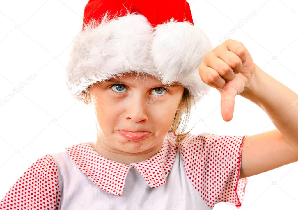 Displeased Little Girl in Santa Hat make Thumb Down on the White Background