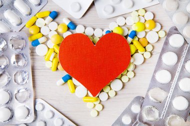 Kırmızı kalp şekli ile tablo closeup haplarla