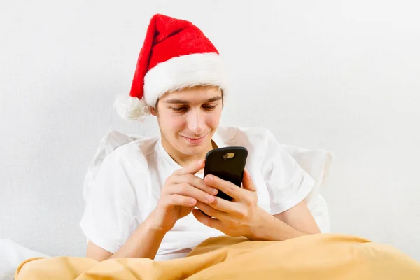 Hombre Joven Santa Sombrero Con Teléfono Cama —  Fotos de Stock