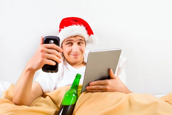 Νεαρός Άνδρας Καπέλο Santa Έναν Υπολογιστή Tablet Και Ένα Τηλέφωνο — Φωτογραφία Αρχείου