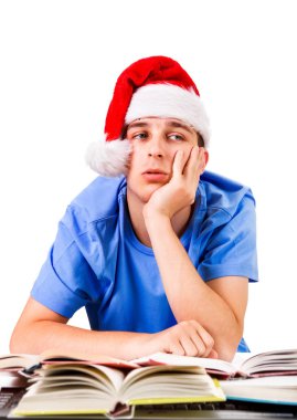 Noel Baba'nın şapkalı beyaz arka plan üzerinde izole okul masasında yorgun ve bıkkın öğrenci