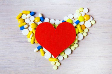 Kırmızı kalp şekli ile tablo closeup haplarla