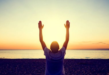 Fotoğraf adam silueti deniz arka plan üzerinde günbatımında dua tonda