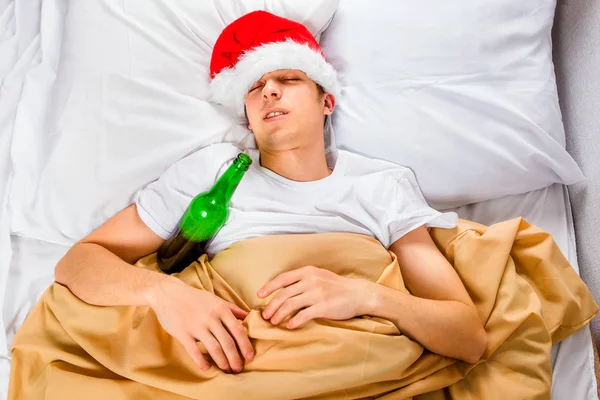 Giovane Santa Hat Dormire Nel Letto Con Una Bottiglia Birra — Foto Stock