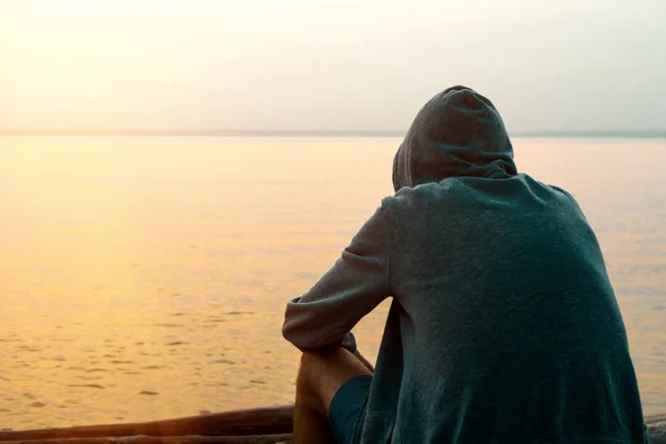 Tónovaný Fotografie Osamělý Mladý Muž Hoodie Sit Pozadí Moře — Stock fotografie