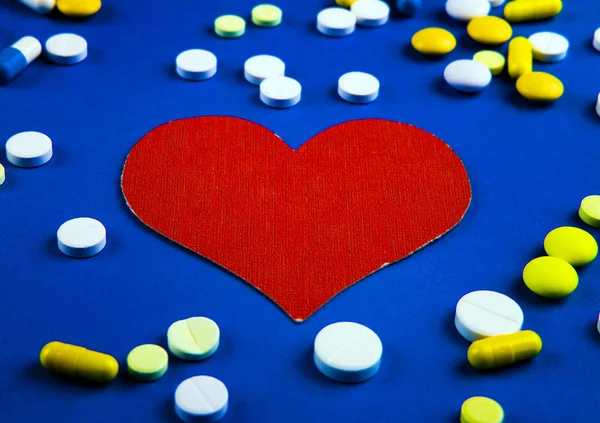 Forma Corazón Rojo Con Una Píldora Fondo Papel Azul — Foto de Stock