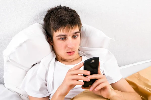 Joven Sorprendido Con Teléfono Cama Casa — Foto de Stock