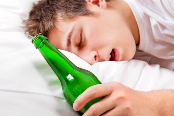 Joven Duerme Con Una Botella Cerveza Cama Del Hogar Enfoque —  Fotos de Stock