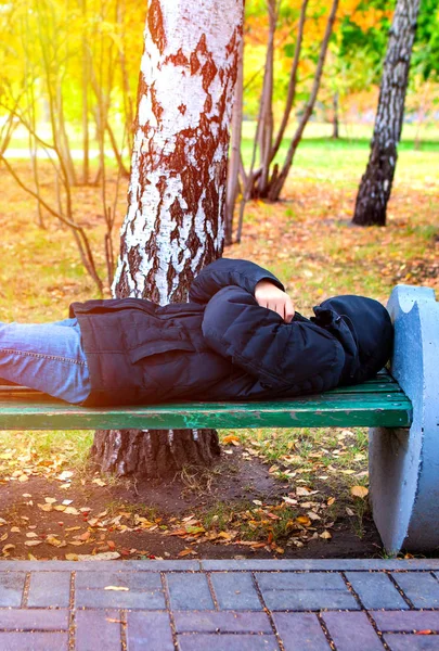 在秋园的长椅上 无家可归的人睡在长椅上 — 图库照片