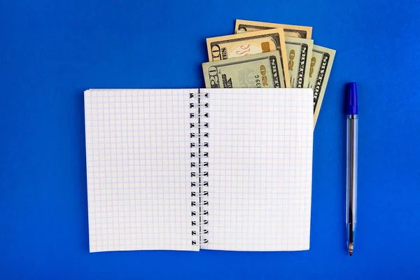 Writing Pad with a Money on the Blue Paper closeup