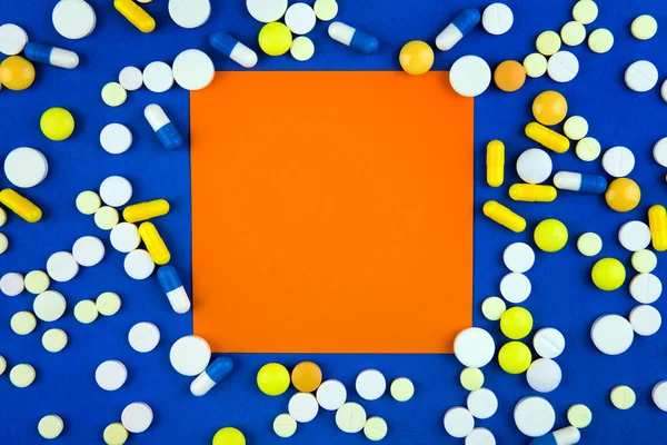 Pillen Und Leeres Orangefarbenes Papier Auf Blauem Papphintergrund — Stockfoto