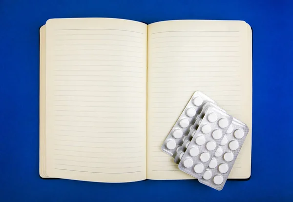 Schreibblock Und Die Pillen Auf Dem Blauen Papier Nahaufnahme — Stockfoto
