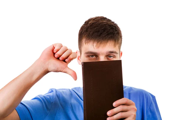 无聊的年轻人与书显示拇指下来的手势在白色背景 — 图库照片