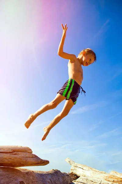 夏のビーチでジャンプ幸せな子 — ストック写真