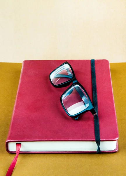 Rotes Buch Mit Einer Brille Auf Dem Braunen Papierhintergrund Nahaufnahme — Stockfoto