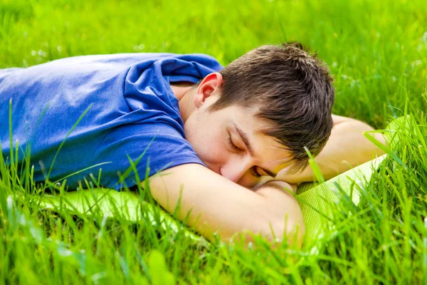 Молодой человек спит на траве — стоковое фото