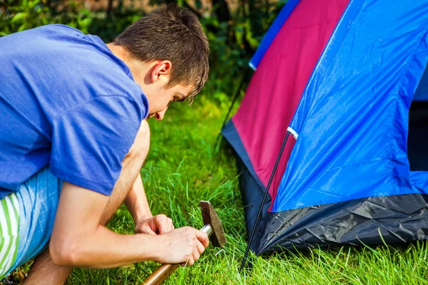 Человек, устанавливающий палатку — стоковое фото