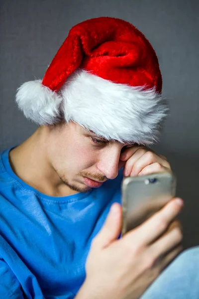 Noel Baba şapkası üzgün genç adam — Stok fotoğraf