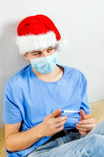 Nemocný mladý muž v Santa klobouku — Stock fotografie