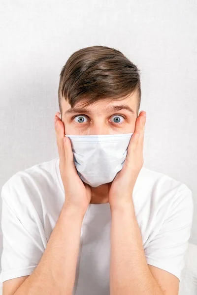 Joven Sorprendido Una Máscara Gripe Por Primer Plano Pared Blanca — Foto de Stock