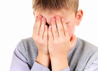 Hüzünlü genç çocuk yüzünü kapatır Beyaz arka planda izole bir şekilde.