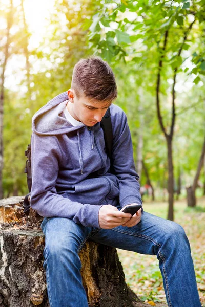 Töprengő Fiatalember Telefonnal Őszi Parkban — Stock Fotó