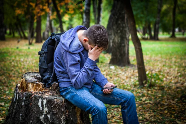 Trauriger Junger Mann Mit Handy Herbstpark — Stockfoto