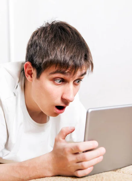 Έκπληκτος Νεαρός Άνδρας Ένα Tablet Computer Στο Κοντινό Καναπέ — Φωτογραφία Αρχείου
