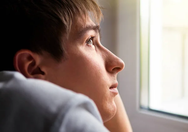 Pensive Young Man by the Window in the Room closeup