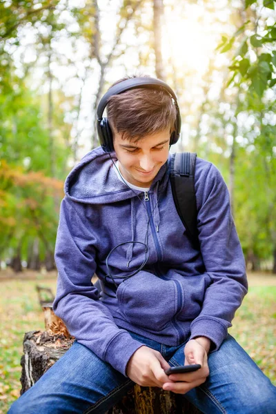 Unge Man Hörlurar Håller Telefon Och Lyssnar Musiken Skogen — Stockfoto