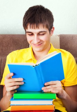 Genç adam evdeki kanepe üzerine bir kitap okudu.