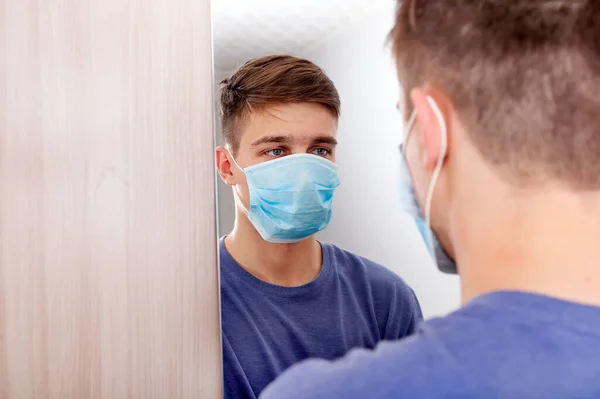 Hombre Joven Con Máscara Gripe Mirando Reflexión Espejo Habitación — Foto de Stock
