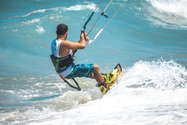 Kitesurfing. Gemide dalga deniz üzerinde uçan genç adam