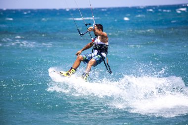 Kitesurfing. Gemide dalga deniz üzerinde uçan genç adam