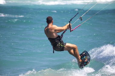 Kitesurfing. Gemide dalga deniz üzerinde uçan genç adam