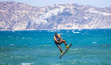 Kitesurfing. Gemide dalga deniz üzerinde uçan genç adam