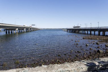 Houghton Köprüsü (solda) ve fiili Hays giriş balıkçılık ve eğlence platformu (sağda), arasında eski Hoonibrook Köprüsü, Redcliffe yarımadasında ilk köprü kalıntıları görüntülemek