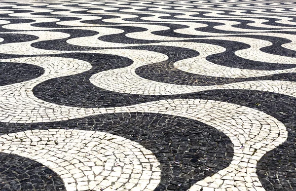 Traditional style Portuguese pavement, designed with black and White stones of basalt and limestone, used in pedestrian areas of Portugal