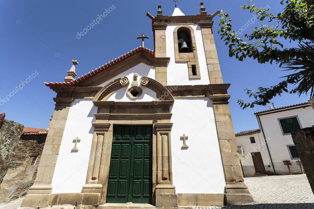 Main facade of the parish church built in the 14th century and renovated in late 17th century with a straight lintel on the portal framed by pilasters, in the village of Castelo Melhor, Portugal